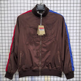 Barca Brown jacket with red and blue accents on a hanger against a grid background