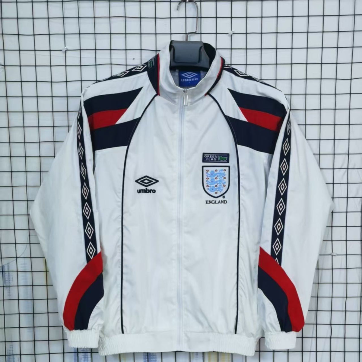 England White tracksuit with red and blue accents on a checkered background